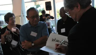 Stan Sakai signing his work at the opening